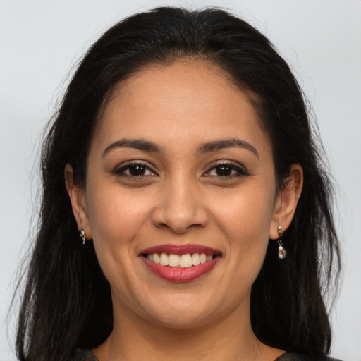 Joyful latino young-adult female with long  brown hair and brown eyes