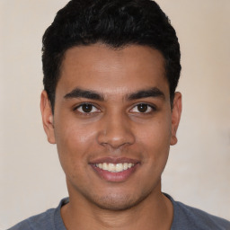 Joyful latino young-adult male with short  black hair and brown eyes