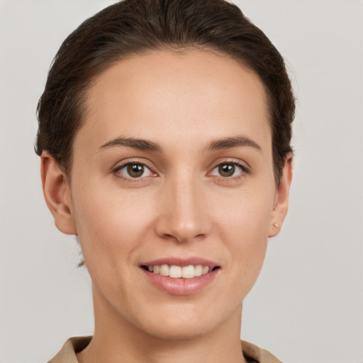 Joyful white young-adult female with short  brown hair and grey eyes