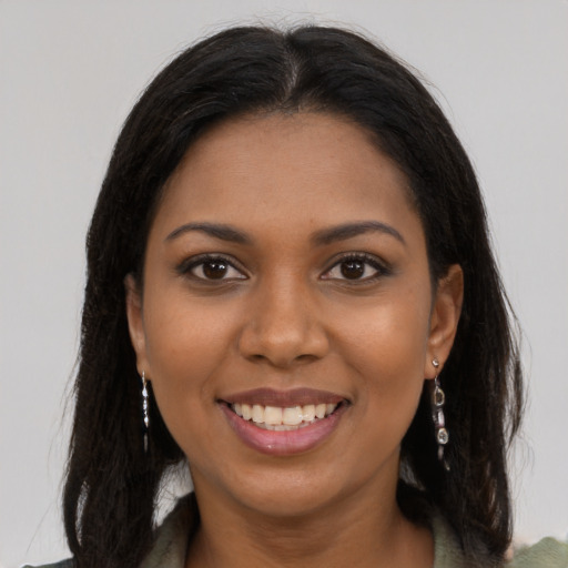 Joyful black young-adult female with long  brown hair and brown eyes