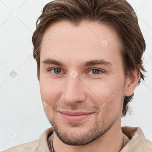 Joyful white young-adult male with short  brown hair and grey eyes