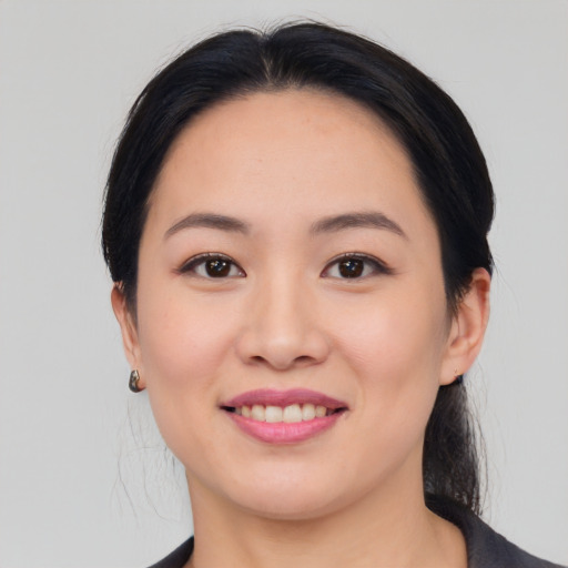 Joyful asian young-adult female with medium  black hair and brown eyes
