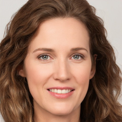 Joyful white young-adult female with long  brown hair and green eyes