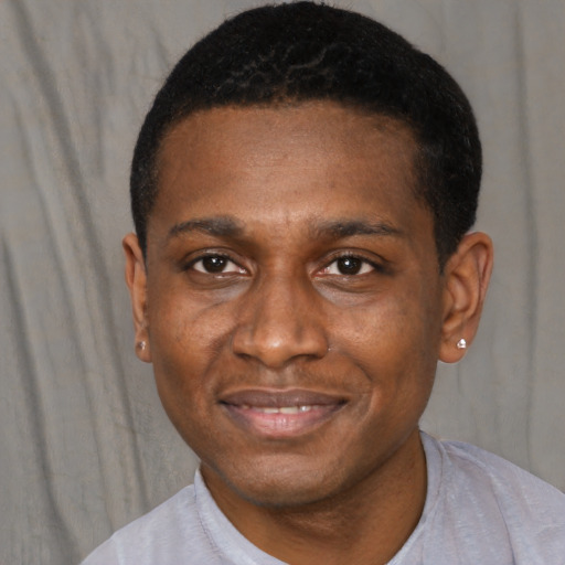 Joyful black young-adult male with short  black hair and brown eyes