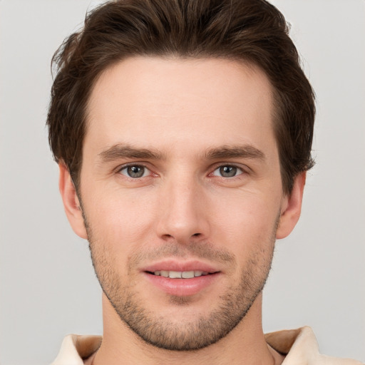 Joyful white young-adult male with short  brown hair and grey eyes