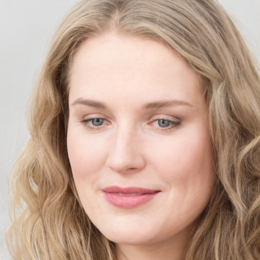 Joyful white young-adult female with long  brown hair and blue eyes