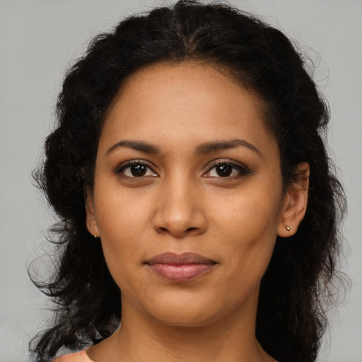 Joyful latino young-adult female with long  brown hair and brown eyes