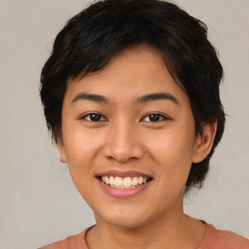 Joyful asian young-adult female with short  brown hair and brown eyes