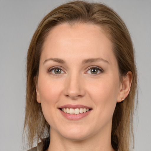 Joyful white young-adult female with long  brown hair and blue eyes