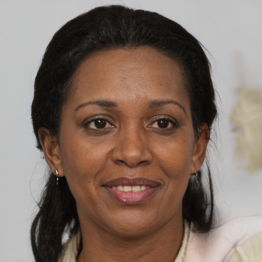 Joyful black adult female with medium  brown hair and brown eyes