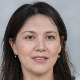 Joyful white adult female with long  brown hair and brown eyes