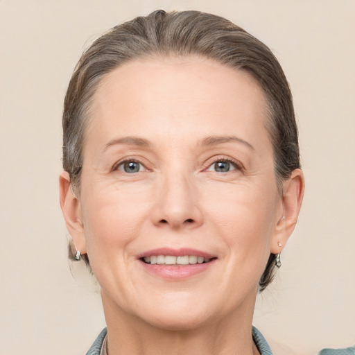 Joyful white adult female with medium  brown hair and grey eyes