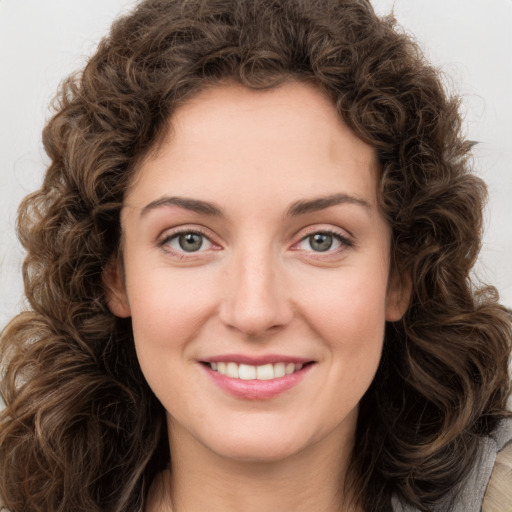 Joyful white young-adult female with long  brown hair and green eyes