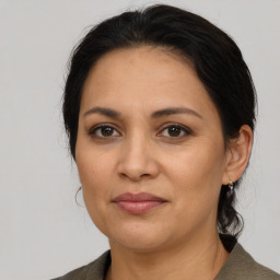 Joyful latino adult female with medium  brown hair and brown eyes