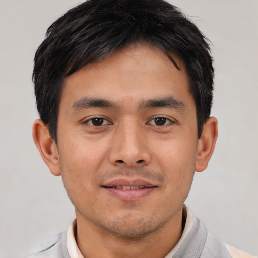 Joyful asian young-adult male with short  black hair and brown eyes