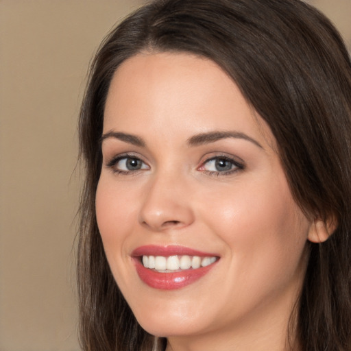 Joyful white young-adult female with long  brown hair and brown eyes