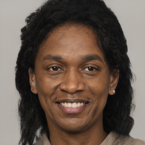 Joyful black adult male with long  black hair and brown eyes