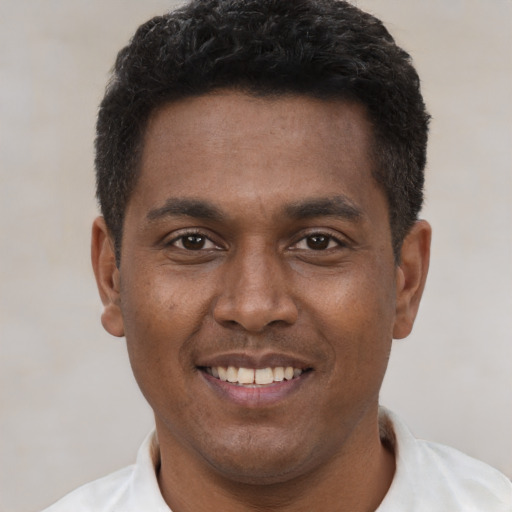 Joyful latino young-adult male with short  brown hair and brown eyes