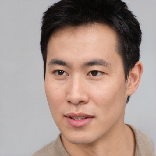 Joyful asian young-adult male with short  brown hair and brown eyes