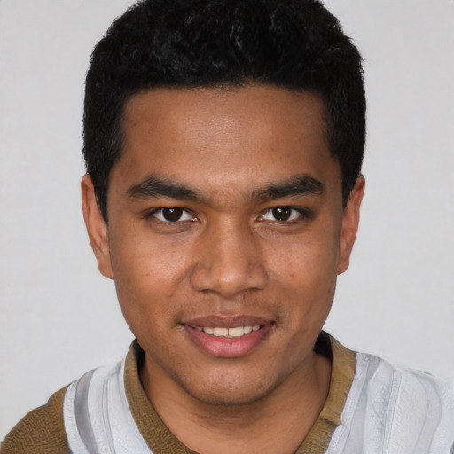 Joyful black young-adult male with short  black hair and brown eyes