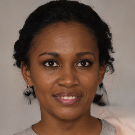 Joyful black young-adult female with short  black hair and brown eyes