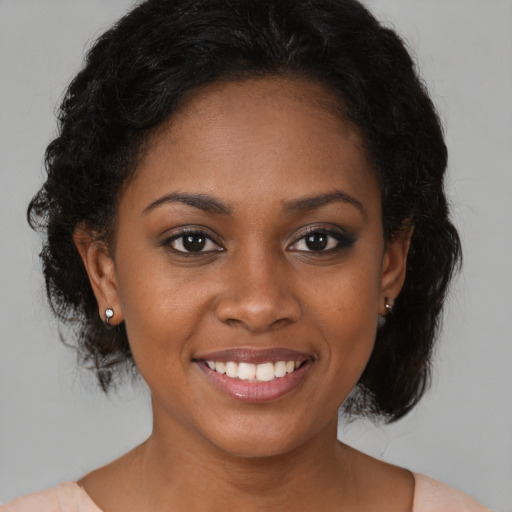 Joyful black young-adult female with medium  brown hair and brown eyes