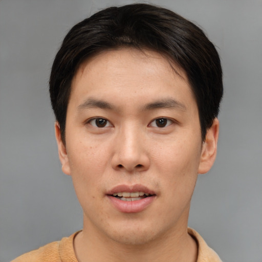 Joyful asian young-adult male with short  brown hair and brown eyes