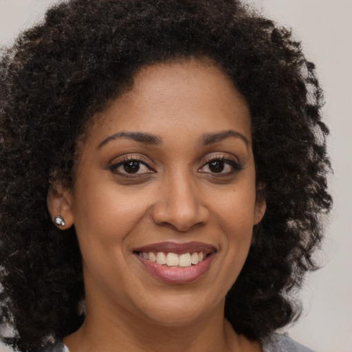 Joyful black young-adult female with medium  brown hair and brown eyes