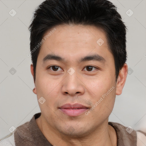 Joyful asian young-adult male with short  brown hair and brown eyes