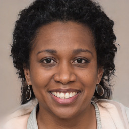 Joyful black young-adult female with long  brown hair and brown eyes