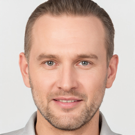 Joyful white young-adult male with short  brown hair and grey eyes