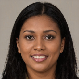 Joyful black young-adult female with long  brown hair and brown eyes