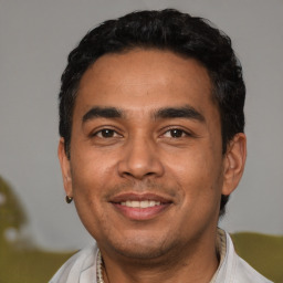 Joyful latino young-adult male with short  black hair and brown eyes