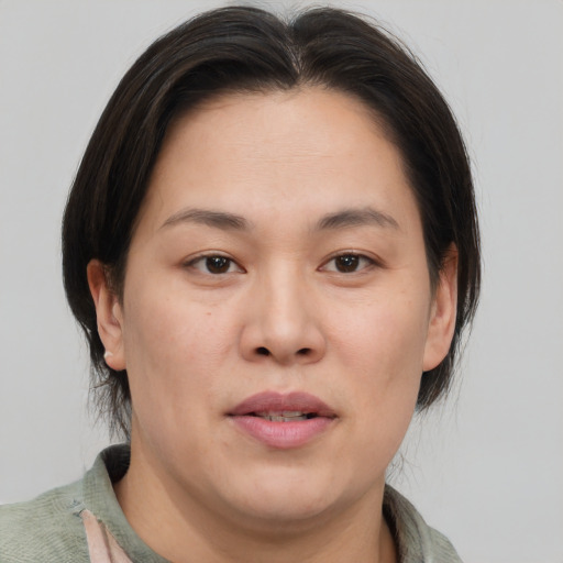 Joyful asian adult female with medium  brown hair and brown eyes