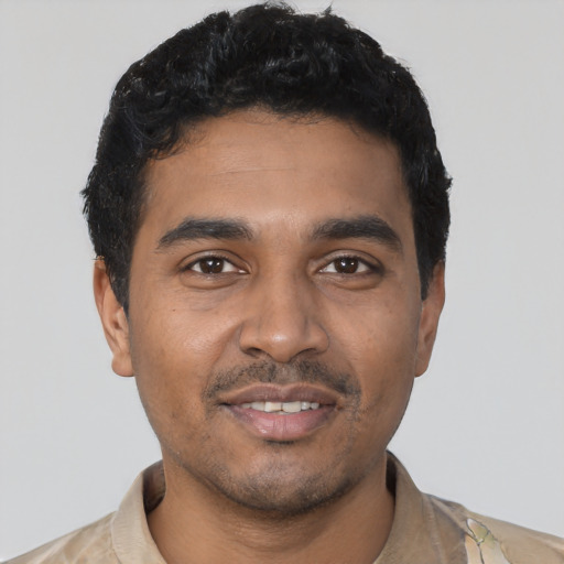Joyful latino young-adult male with short  black hair and brown eyes
