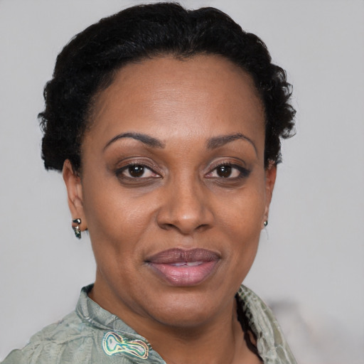 Joyful black adult female with short  black hair and brown eyes