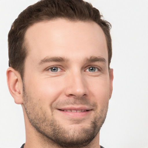 Joyful white young-adult male with short  brown hair and grey eyes