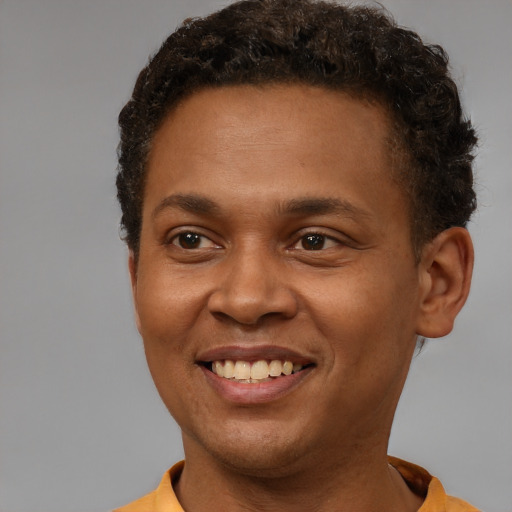 Joyful black young-adult male with short  brown hair and brown eyes