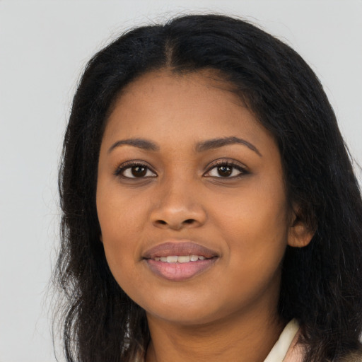 Joyful black young-adult female with long  brown hair and brown eyes