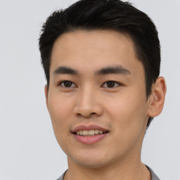 Joyful asian young-adult male with short  black hair and brown eyes