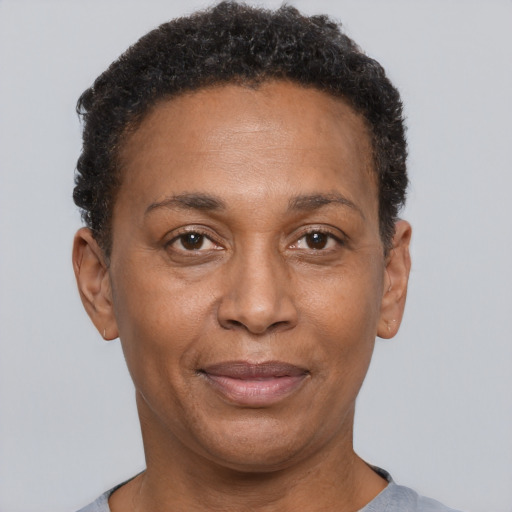 Joyful black adult female with short  black hair and brown eyes