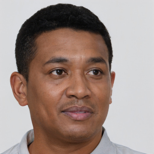 Joyful black young-adult male with short  brown hair and brown eyes