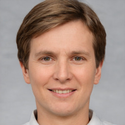 Joyful white adult male with short  brown hair and grey eyes