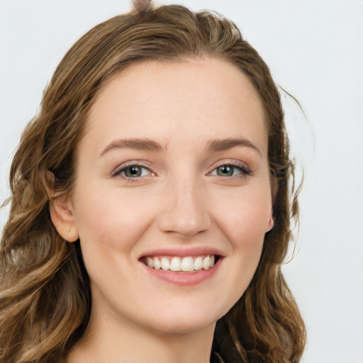 Joyful white young-adult female with long  brown hair and blue eyes