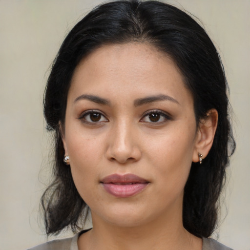 Joyful latino young-adult female with medium  brown hair and brown eyes