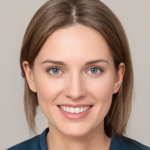 Joyful white young-adult female with medium  brown hair and grey eyes