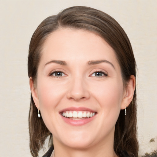 Joyful white young-adult female with medium  brown hair and green eyes