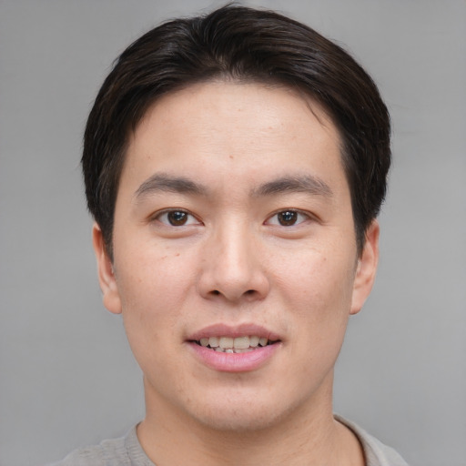 Joyful asian young-adult male with short  brown hair and brown eyes