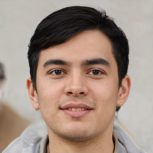 Joyful white young-adult male with short  black hair and brown eyes