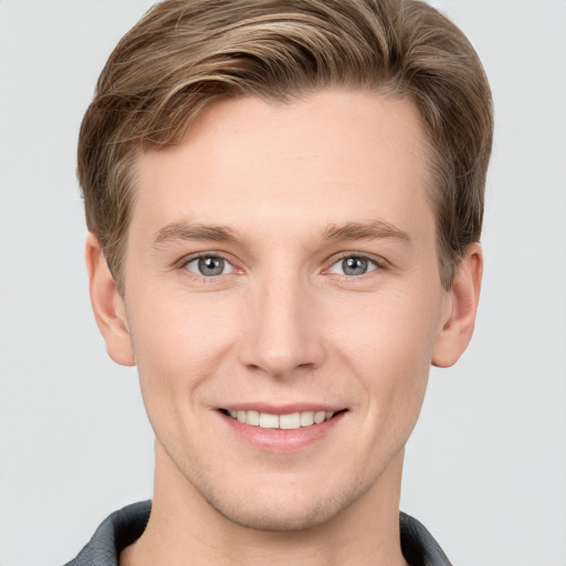 Joyful white young-adult male with short  brown hair and grey eyes